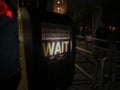 Wait sign at pedestrian crossing at night in London