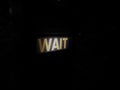 Wait sign at pedestrian crossing at night in London