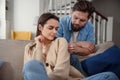 Wait. Worried young man is consoling his girlfriend while touching her arm gently. Woman is holding mobile phone and Royalty Free Stock Photo