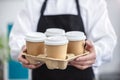 Waiter barista holding a take out paper disposable cup of hot coffee in cafe Royalty Free Stock Photo