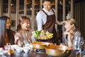 Waiter bring vegetables for hot pot and serving group of friends in