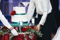 Waiter bring a white wedding cake on the decorated table Royalty Free Stock Photo