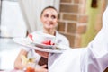 Waiter brings a dish for a nice woman Royalty Free Stock Photo