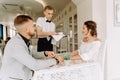 Waiter brought cup of coffee for beautiful couple in a cafe Royalty Free Stock Photo