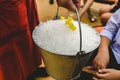 Waiter carrying a metal bucket full of ice to cool drinks in summer