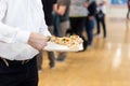 Waiter carrying plates with canapes on some festive event, party or wedding reception Royalty Free Stock Photo