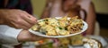 Waiter carrying plates with meat dish on some festive event Royalty Free Stock Photo