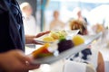 Waiter carrying plates with meat dish on some festive event