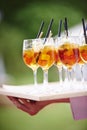 Waiter carrying tray of cocktails with straws