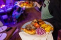 Waiter carrying two plates with meat dish on some festive event, party, wedding reception or catered event. Royalty Free Stock Photo