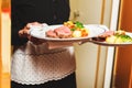 Waiter carrying two plates with meat dish Royalty Free Stock Photo