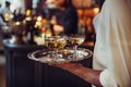 Waiter from catering service carrying champagne wine drinks on the tray at event. Royalty Free Stock Photo