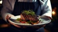 waiter cook holds in his hands a dish of meat steak fried