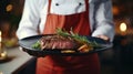 waiter cook holds in his hands a dish of meat steak fried