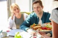 The waiter delivers salad to guests sitting in cafe