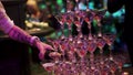 The waiter filled champagne fountain pyramid of glasses. Bottle of champagne being poured into a glass pyramid. People