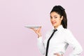 A waiter girl with empty plate poses on pink background