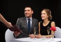 Waiter giving menu to happy couple at restaurant