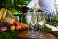 Waiter hands pour chilled champagne in glasses