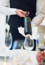Waiter hands, wine and restaurant table with white towel, luxury hospitality and vintage for fine dining. Man, bottle