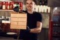 Waiter is holding bunch of paper eco boxes in the cafe. Order is ready Royalty Free Stock Photo