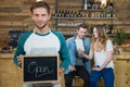 Waiter holding chalkboard with open sign and customer in background Royalty Free Stock Photo