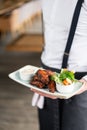 The waiter is holding a plate chicken wings grill. Barbecue restaurant menu, a series of photos of different meats Royalty Free Stock Photo