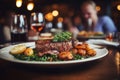 Waiter holding a plate with grilled beef steak with roasted vegetables on a side. Serving fancy food in a restaurant Royalty Free Stock Photo