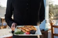 Waiter is holding plate with ready-made dish in his hand Royalty Free Stock Photo