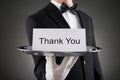 Waiter Holding Plate With The Text Thank You On Paper