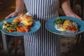 Waiter holding plates with tasty dishes Royalty Free Stock Photo