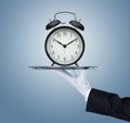 Waiter holding silver tray with a clock Royalty Free Stock Photo