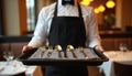 Waiter holds tray with silverware ready to serve at restaurant. Pro server in uniform. Table setting, dining, culinary, service Royalty Free Stock Photo