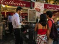 Waiter hovers while couple studies menu at Montmartre restaurant Royalty Free Stock Photo