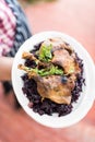 Waiter with large platter- duck confit and wine braised cabbage