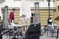 Waiter with a mask disinfects the table of an outdoor bar, cafÃÂ© or restaurant