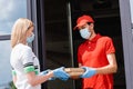 Waiter in medical mask giving pizza