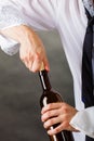 Waiter opens wine bottle. Royalty Free Stock Photo