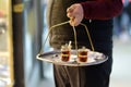 The waiter of outdoors cafe is serving tray with glasses of traditional turkish tea. Istanbul, Turkey