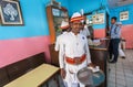 Waiter of popular indian cafe in ethnic dress working in colorful interior