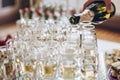 Waiter pouring champagne in stylish glasses at luxury wedding re