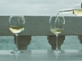 Waiter pouring glass of white wine on outdoor terrace with sea v Royalty Free Stock Photo