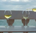 Waiter pouring glass of white wine on outdoor terrace with sea v Royalty Free Stock Photo