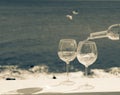 Waiter pouring glass of white wine on outdoor terrace with sea v Royalty Free Stock Photo