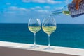 Waiter pouring glass of white wine on outdoor terrace with sea v Royalty Free Stock Photo