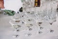 Waiter pouring martini in crystal glasses on table party at wedding reception. Martini row drinks at alcohol bar. Christmas and Royalty Free Stock Photo