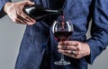 Waiter pouring red wine in a glass. Sommelier man, degustation, winery, male winemaker. Red wine is poured from bottle Royalty Free Stock Photo