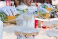 Waiter pours champagne from 2 bottles into crystal glasses with dry ice and white smoke close up. Sparkling wine pouring Royalty Free Stock Photo