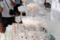 The waiter pours champagne into crystal glasses with dry ice and white smoke close up. Sparkling wine pouring in wine Royalty Free Stock Photo