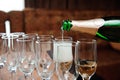 Waiter pours champagne in glasses, luxury event.